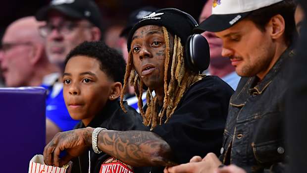 Lil Wayne watches a Lakers game from courtside seats.